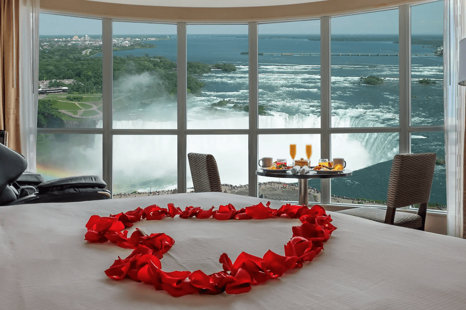 Romantic suite setup featuring rose petals overlooking Niagara Falls.